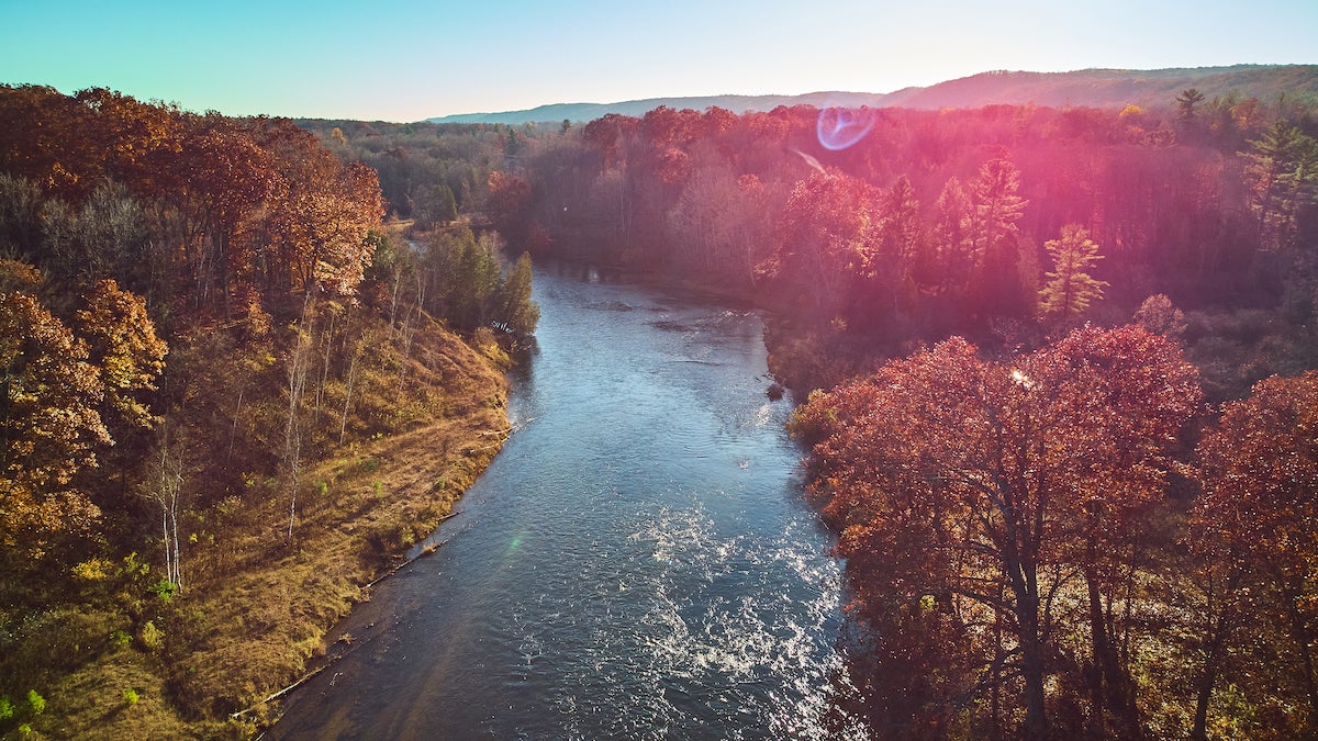 Image of aerial solar flare over Michigan river during late fall with warm colors manistee river trail