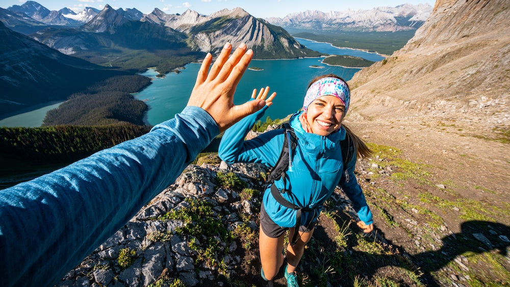 Hikers high-fiving above Kananaskis Lake while hiking the Great Divide Trail.