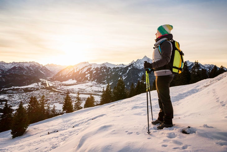 female hiker in winter looking out over peak