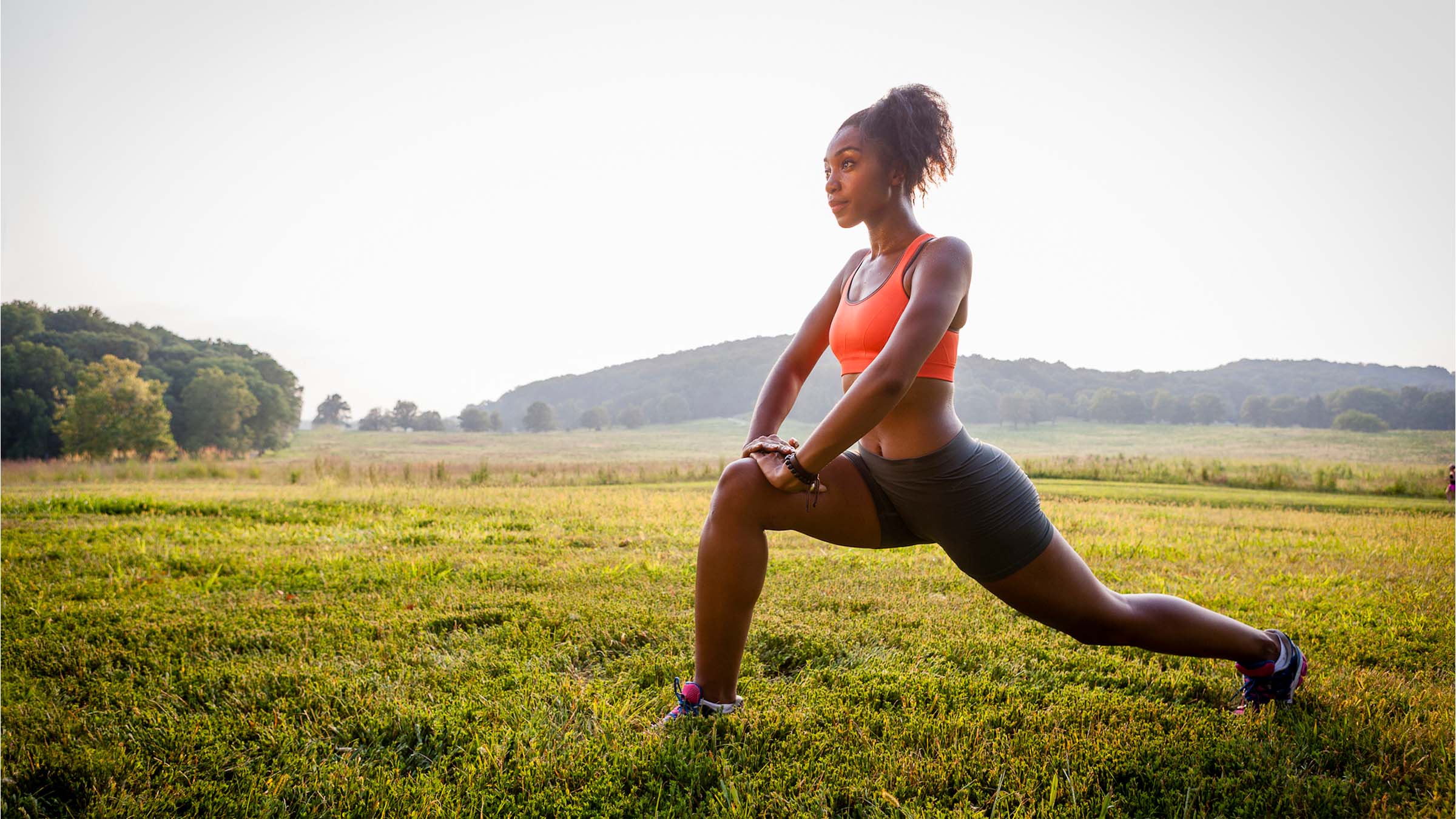 woman lunging in a grassy field
