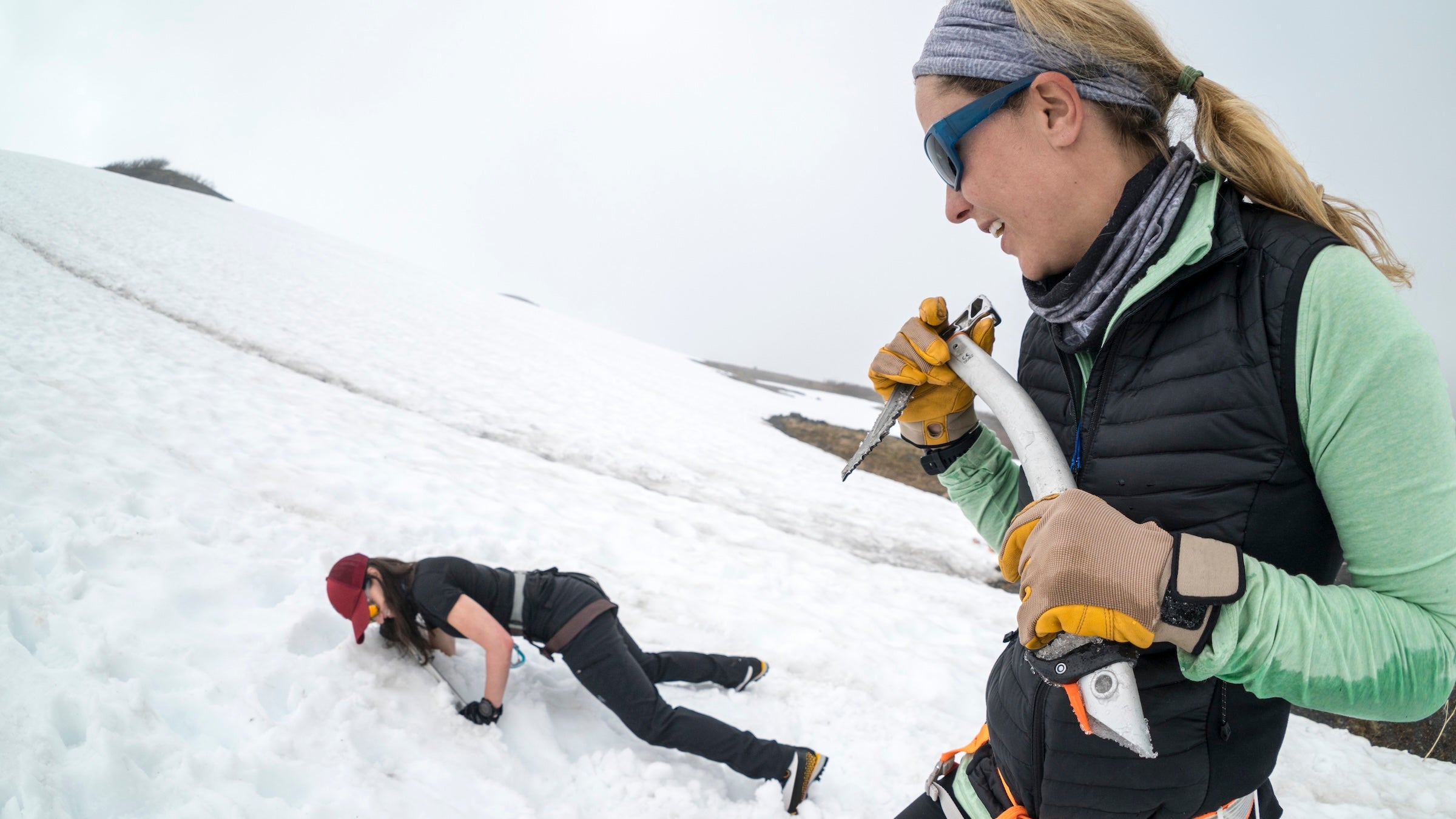 One female mountaineer teaches the other how to self-arrest on Mt. Baker