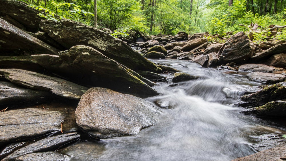 Long exposure of water flowing over rocks in small creek near pinhoti trail