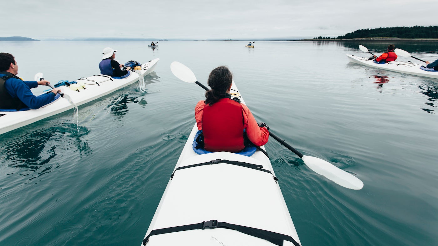 A group of friends sea kayak in pristine waters of Muir Inlet in Glacier Bay National Park, Alaska