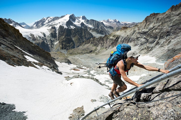 Climbing a ladder to Bertol Hut A woman hiker climbing a ladder to the Bertol Hut on the fourth day of the Chamonix to Zermatt Glacier Haute Route.