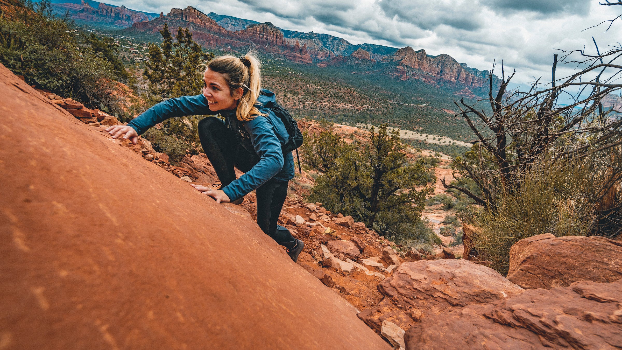 woman climbs up rocks