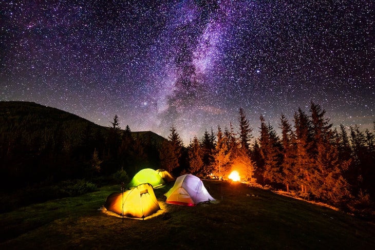 Tent camp in the mountains under a starry sky at night