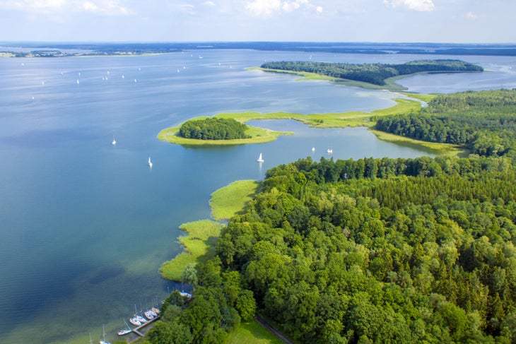 6. Jezioro Mamry _ fot. M. Achtel-istagram101 Water sweeps the landscape surrounded by trees and small islands in Poland's Lake District.