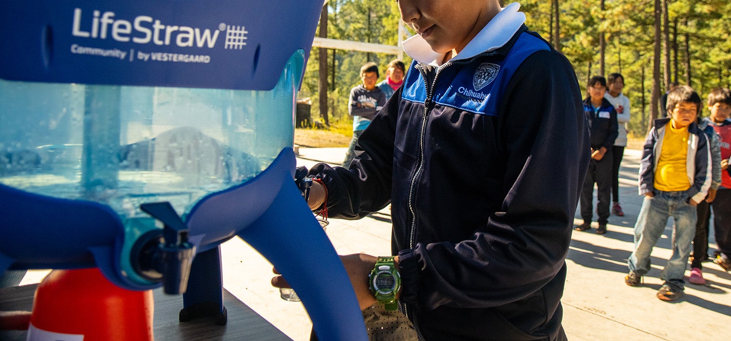"Little boy fills up water at a LifeStraw filter station."