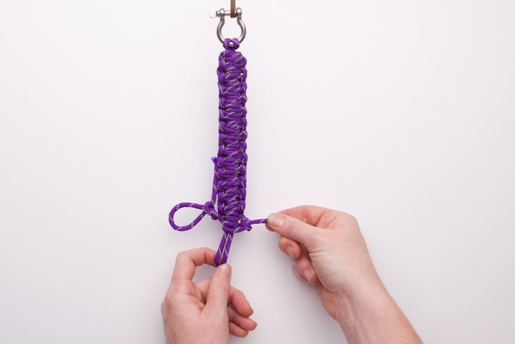 Tirez la ficelle d'extrémité bien serrée. Maintenant, enfilez ces boucles du milieu dans la boucle de gauche et serrez à nouveau la ficelle d'extrémité.