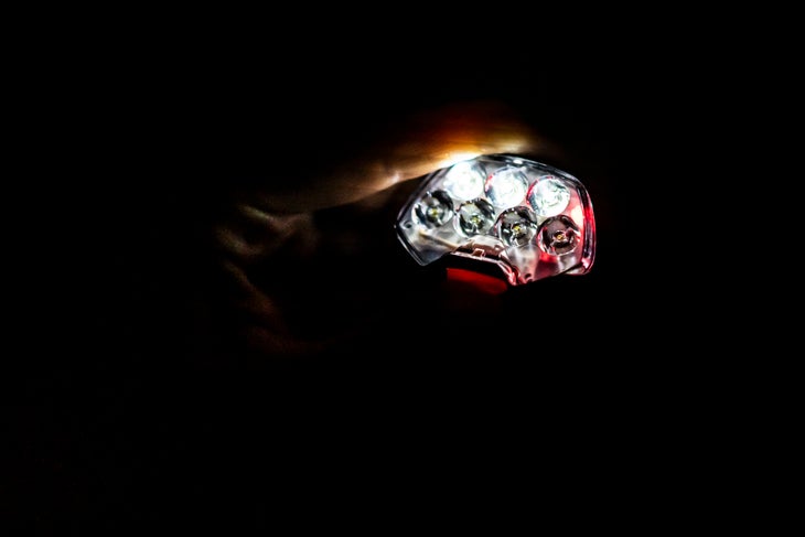 Petzl_strange_18 hand holding headlamp in the dark.