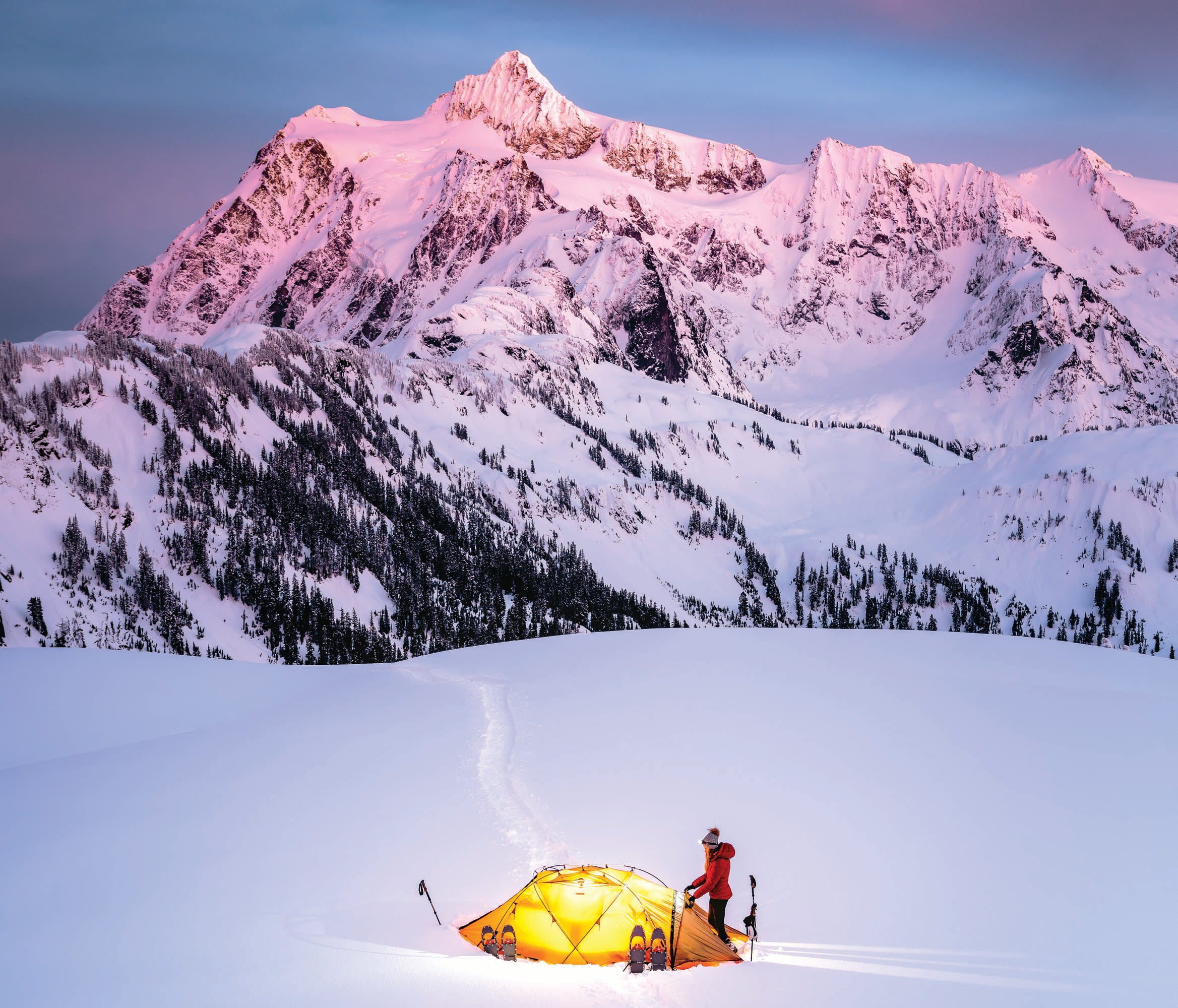 "campsite in snow with mountain in the background"