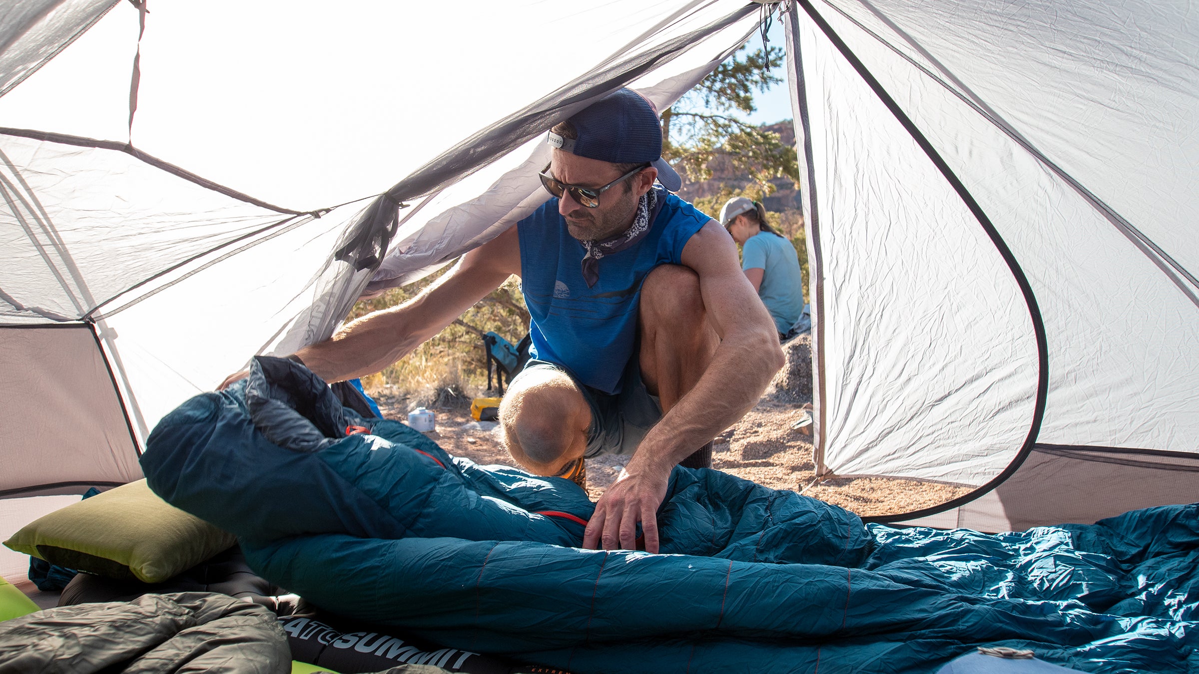 Hiker in tent adjusting sleeping bag