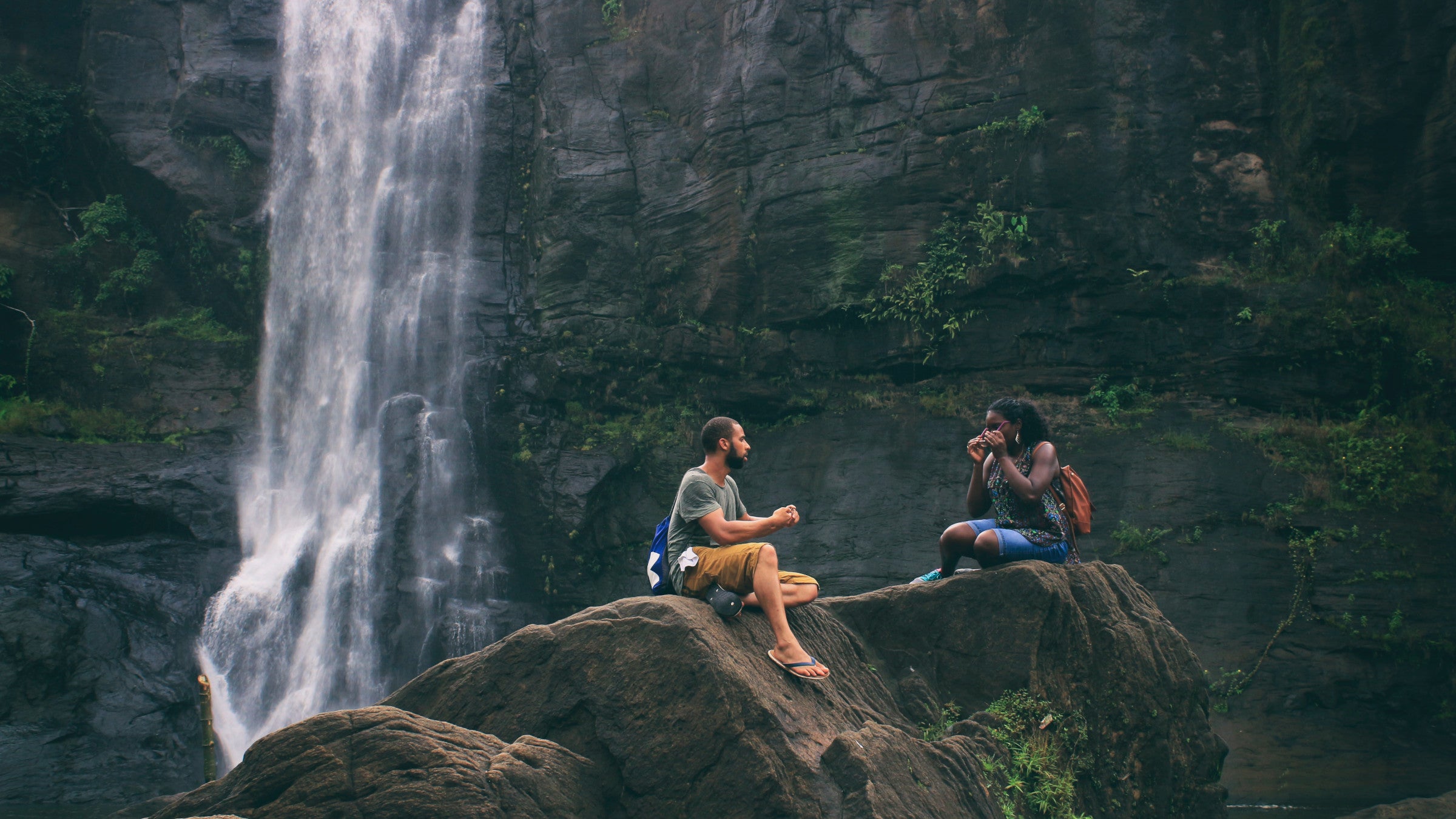 Couple sitting by waterfall