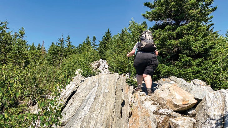 hiker walking up a rock face