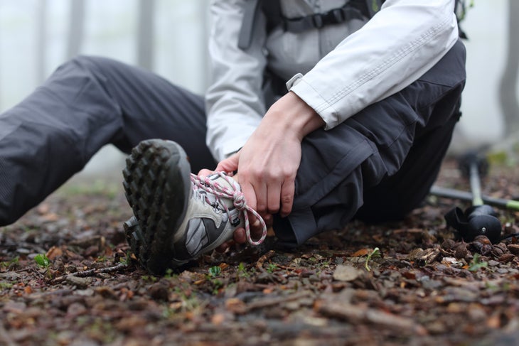 woman hiking alone without knowing how to treat a sprained ankle