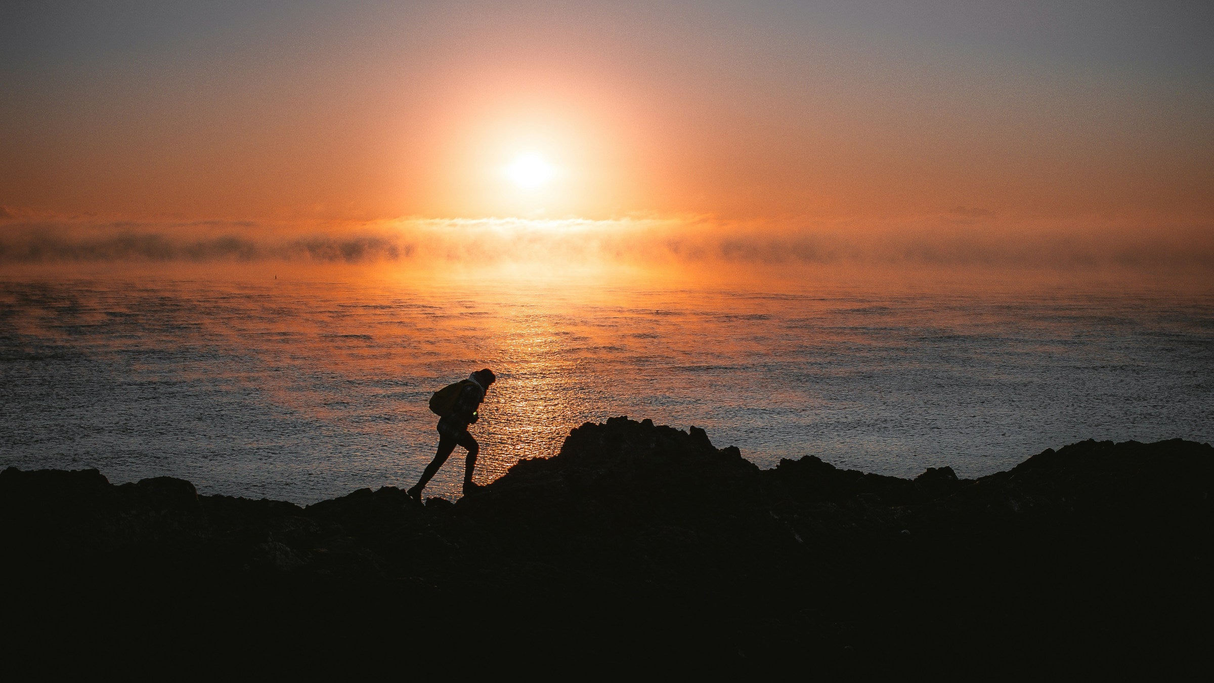Hiker on mountain at sunset