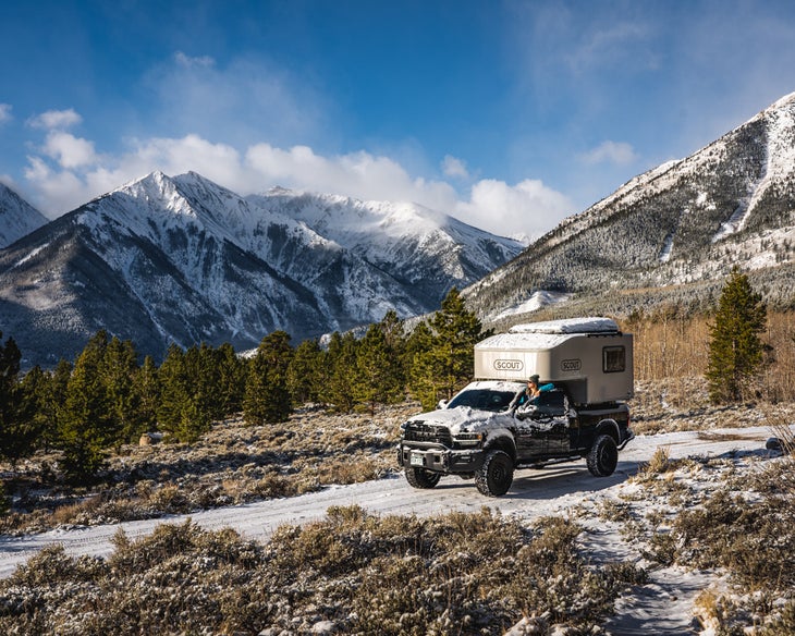 dani mortell stands outside of her truck in the mountains