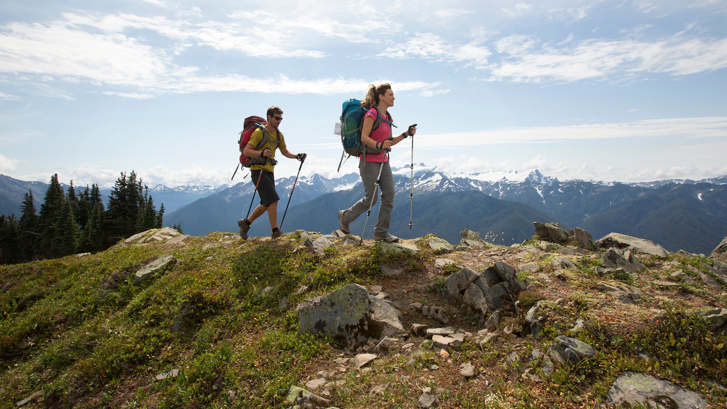 A couple backpacking along a trail in Olympic National Park.