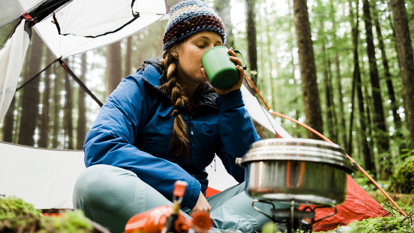 female hiker cooking while backpacking