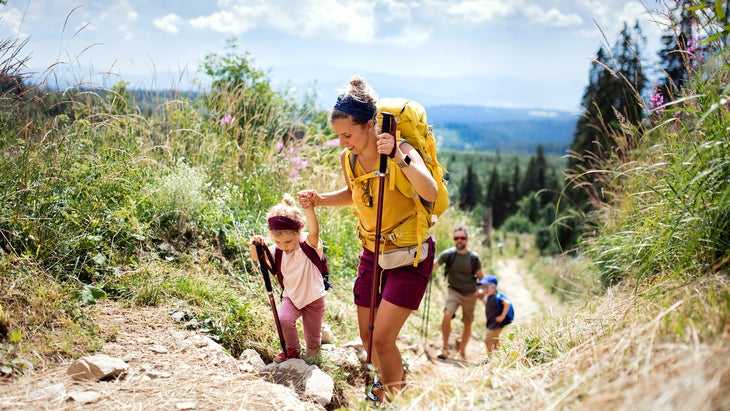 Family with small children hiking outdoors in summer nature, walking in High Tatras.