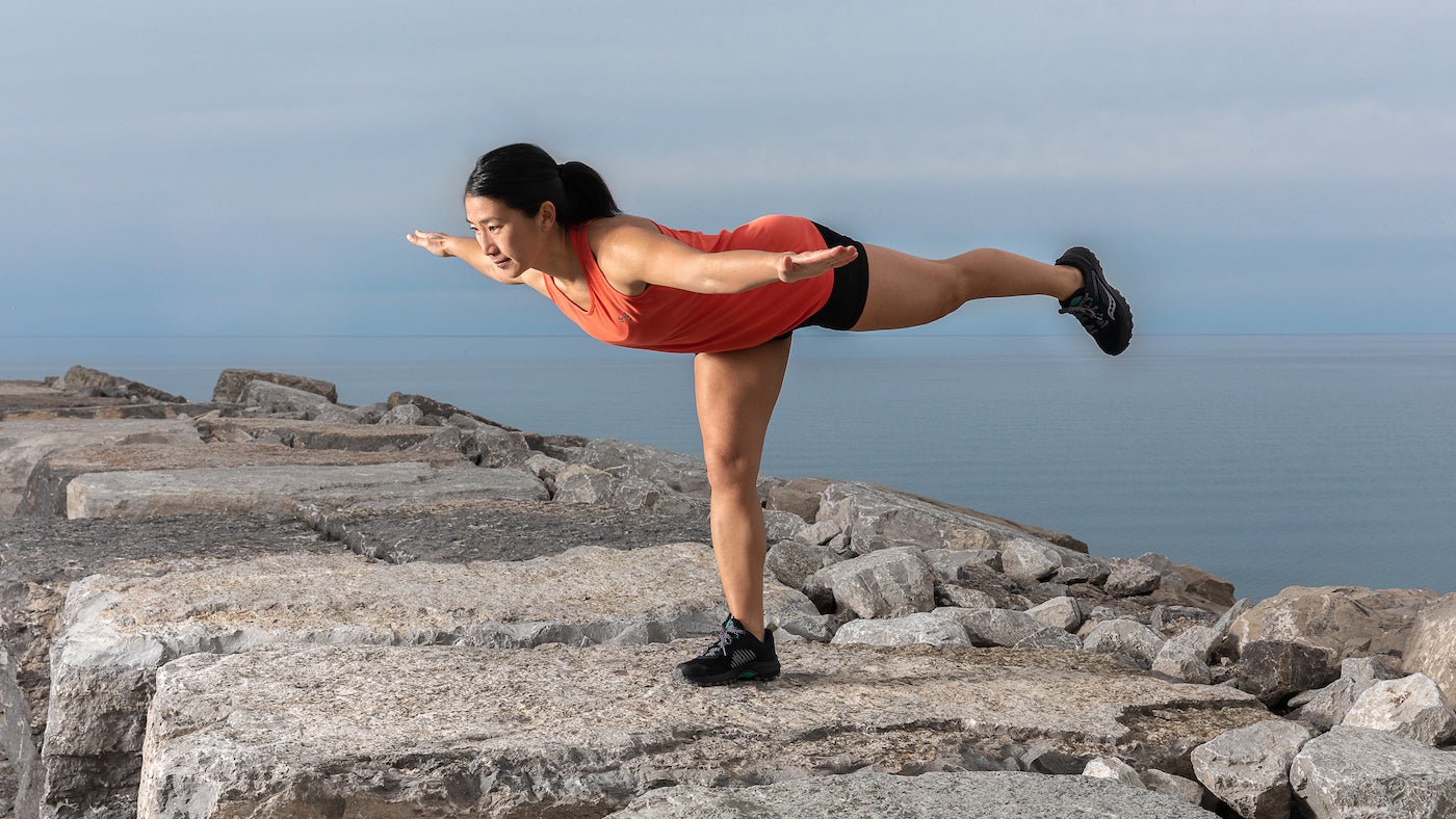 woman practicing mobility exercises on rock