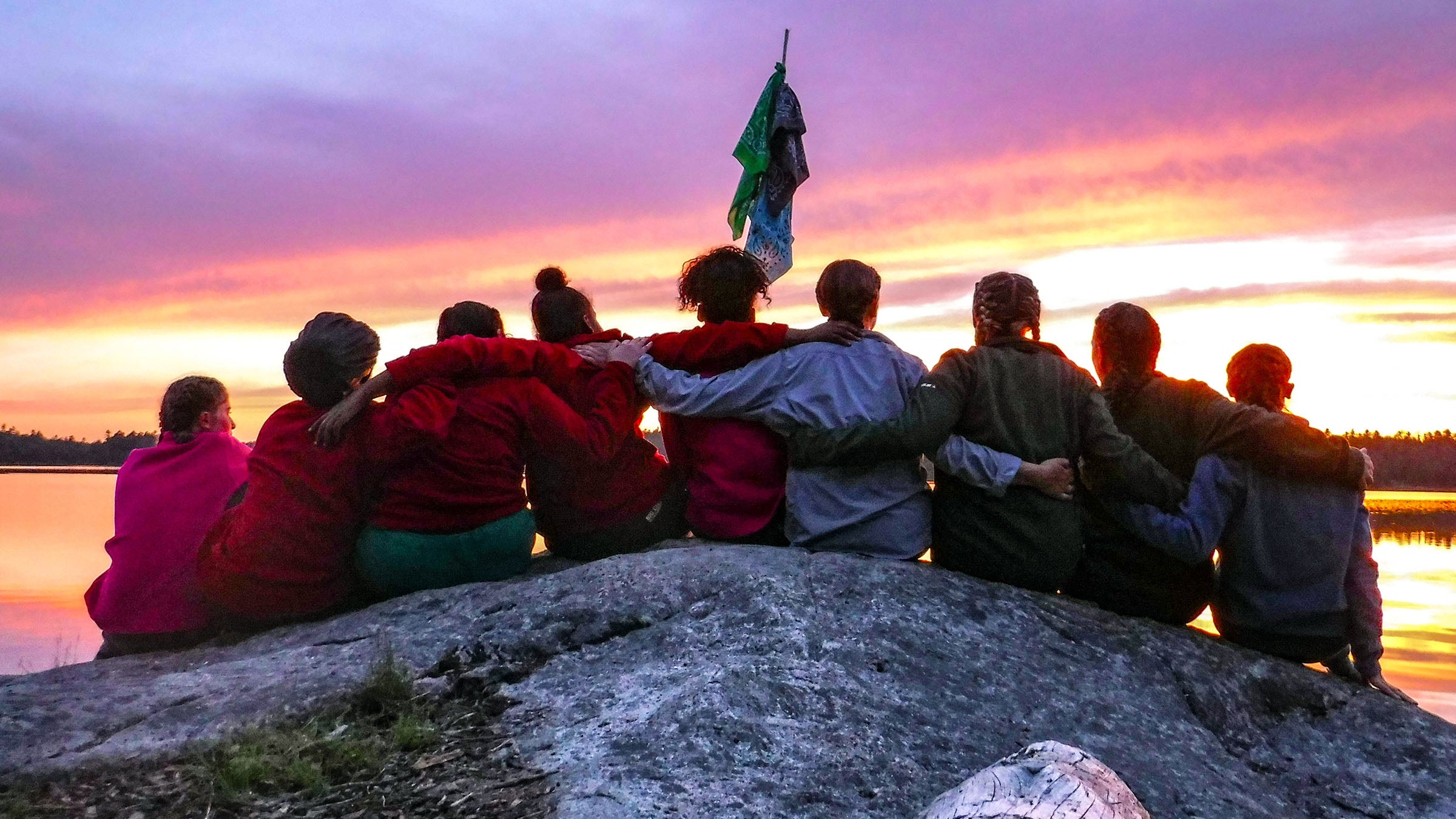 group of hikers sitting on a mountaintop