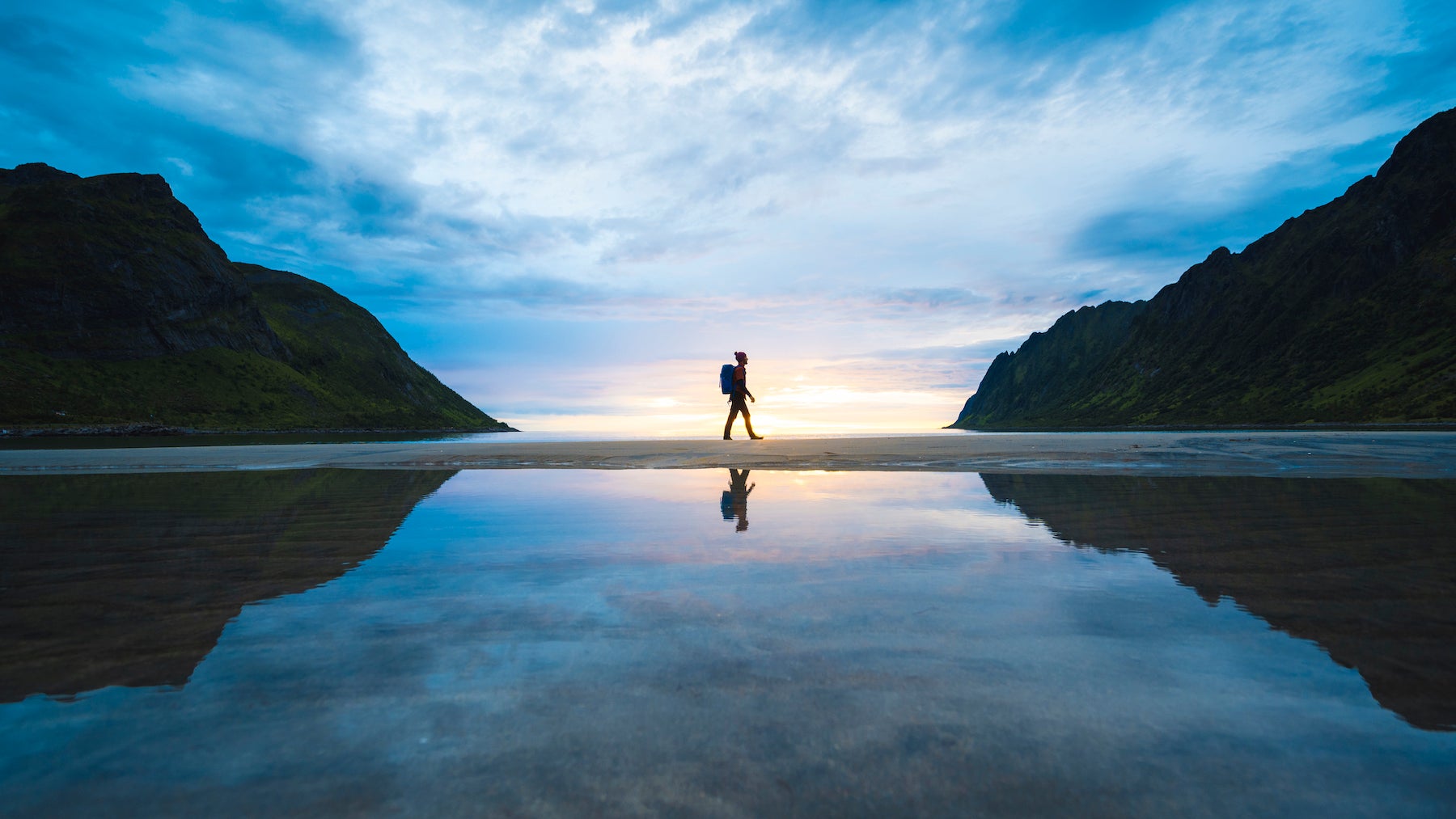 Person walking on the beach at sunset