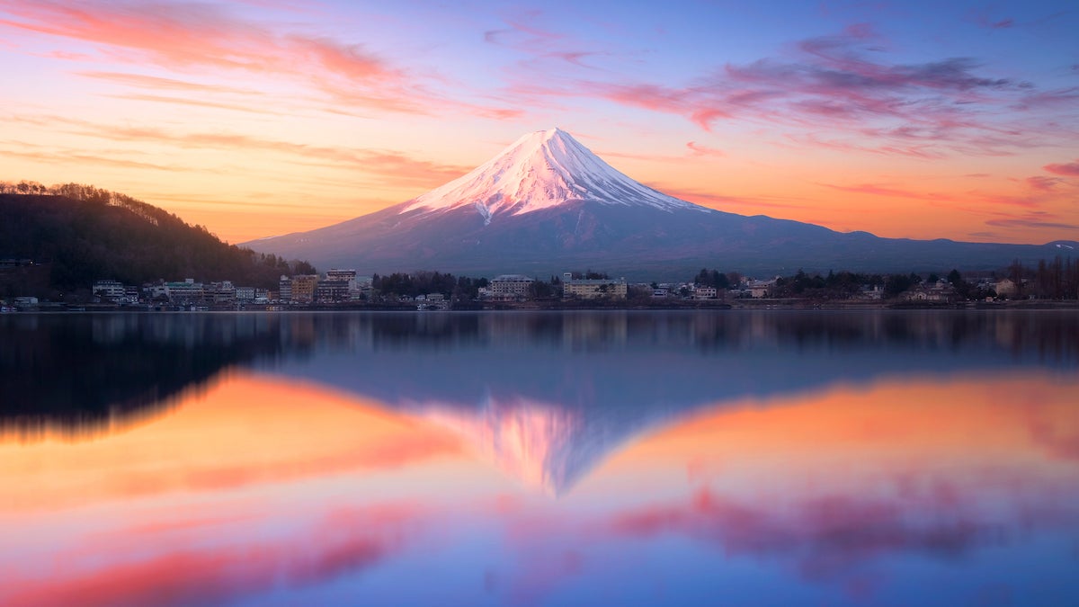 Mount Fuji in morning reflects on water at sunrise