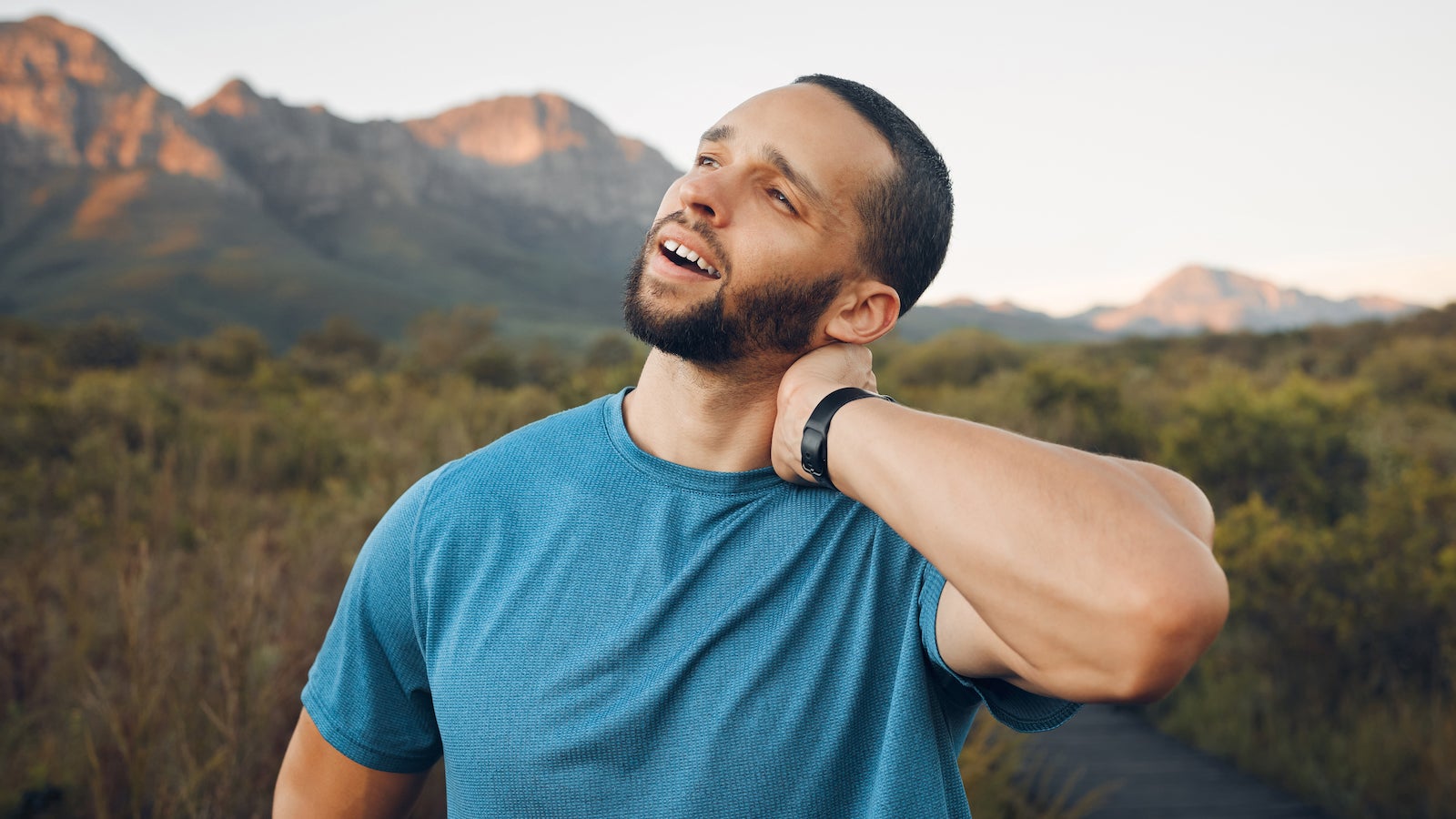 man holding neck from pain in outdoors