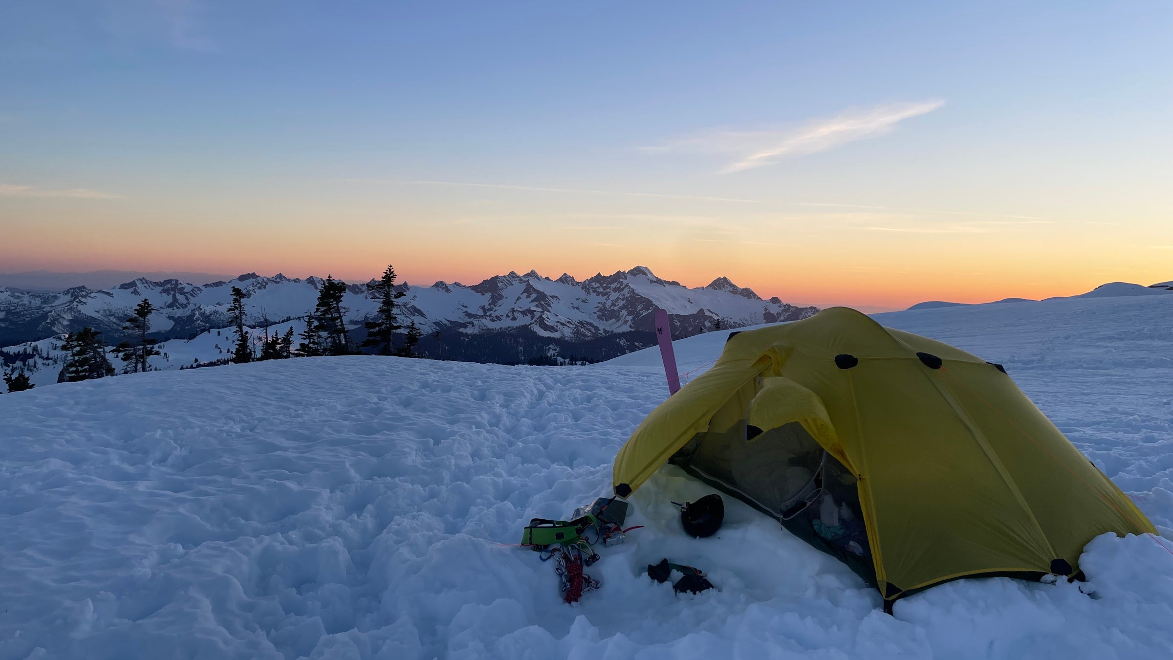 A tent on snow at sunset