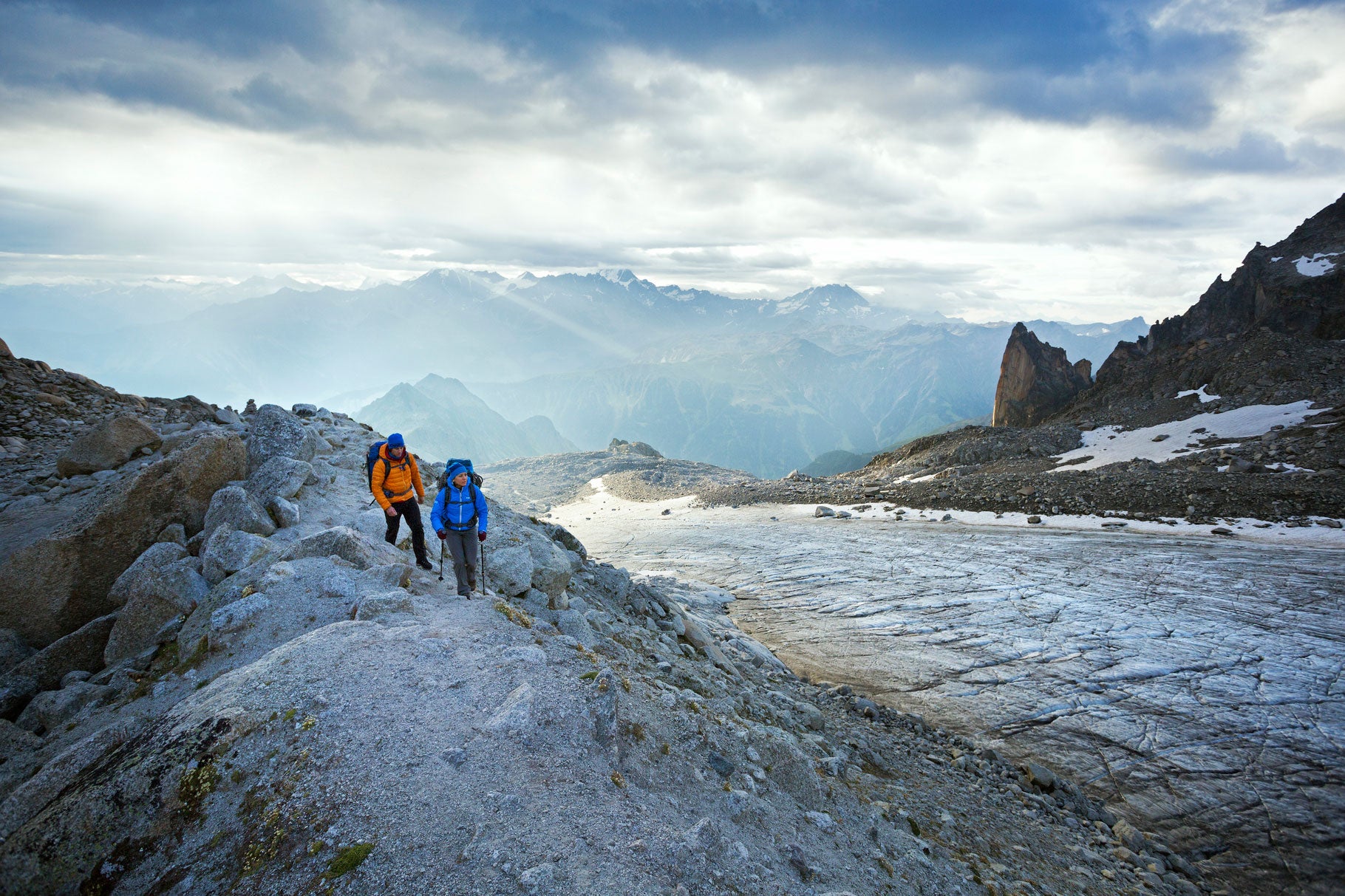 Glacier d'Orny Two hikers walking alongside the Glacier d'Orny on the first day of the Chamonix to Zermatt Glacier Haute Route.